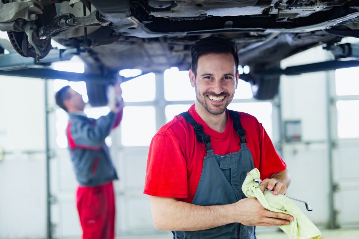 Mechanic working on vehicle in shop