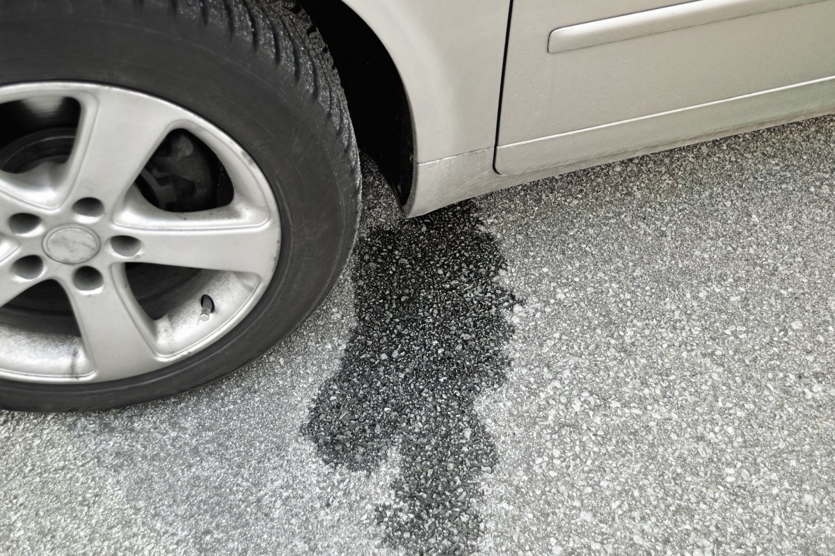 Parked car with a puddle where it is leaking 