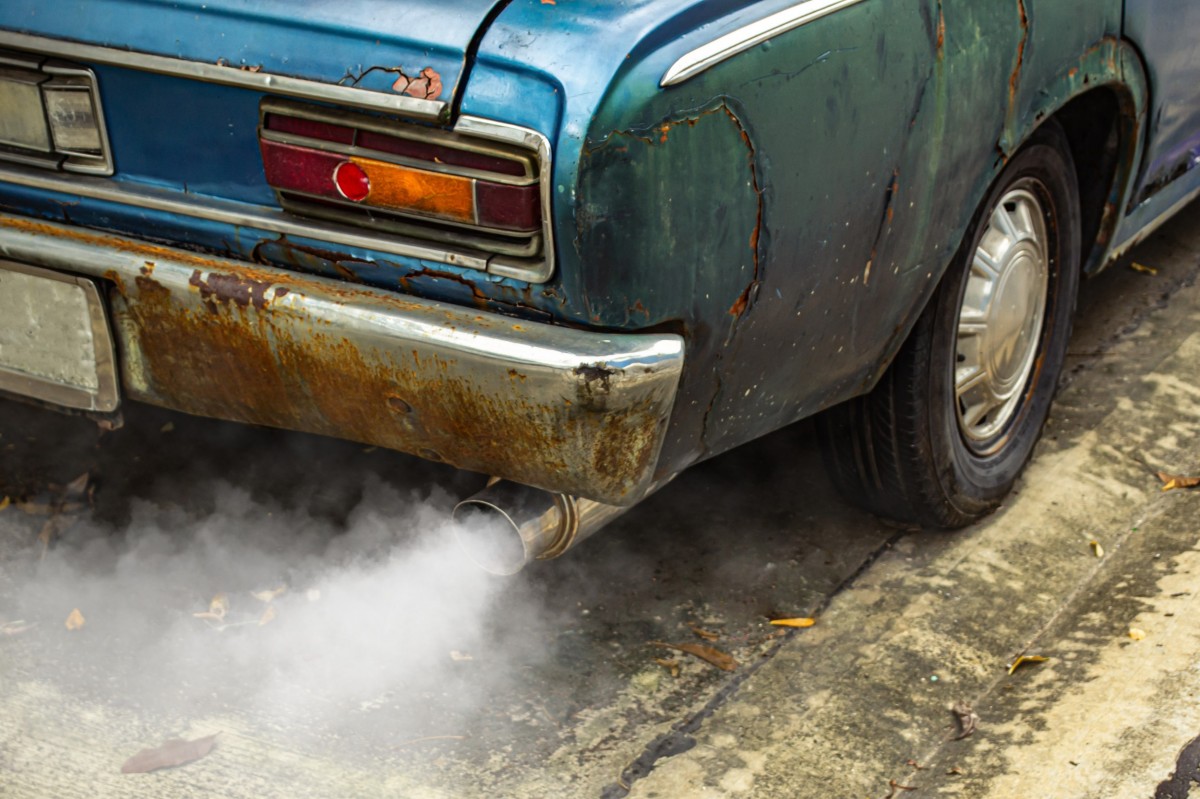 rusted car with smoke coming out of exhaust