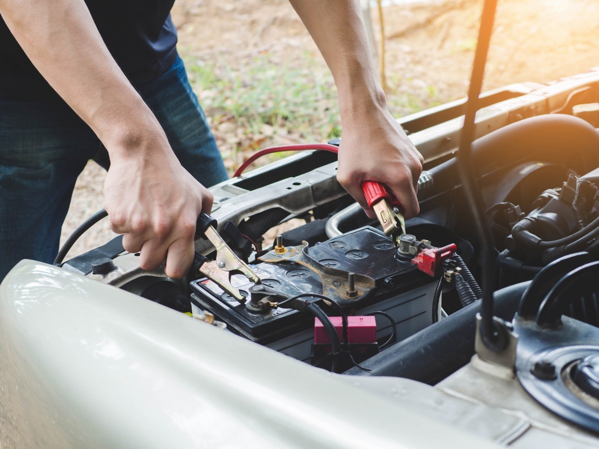 jumper cables being placed on a battery