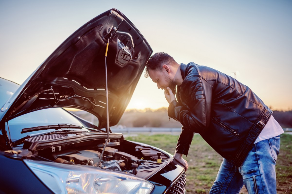 man broke down on side of road with car hood up