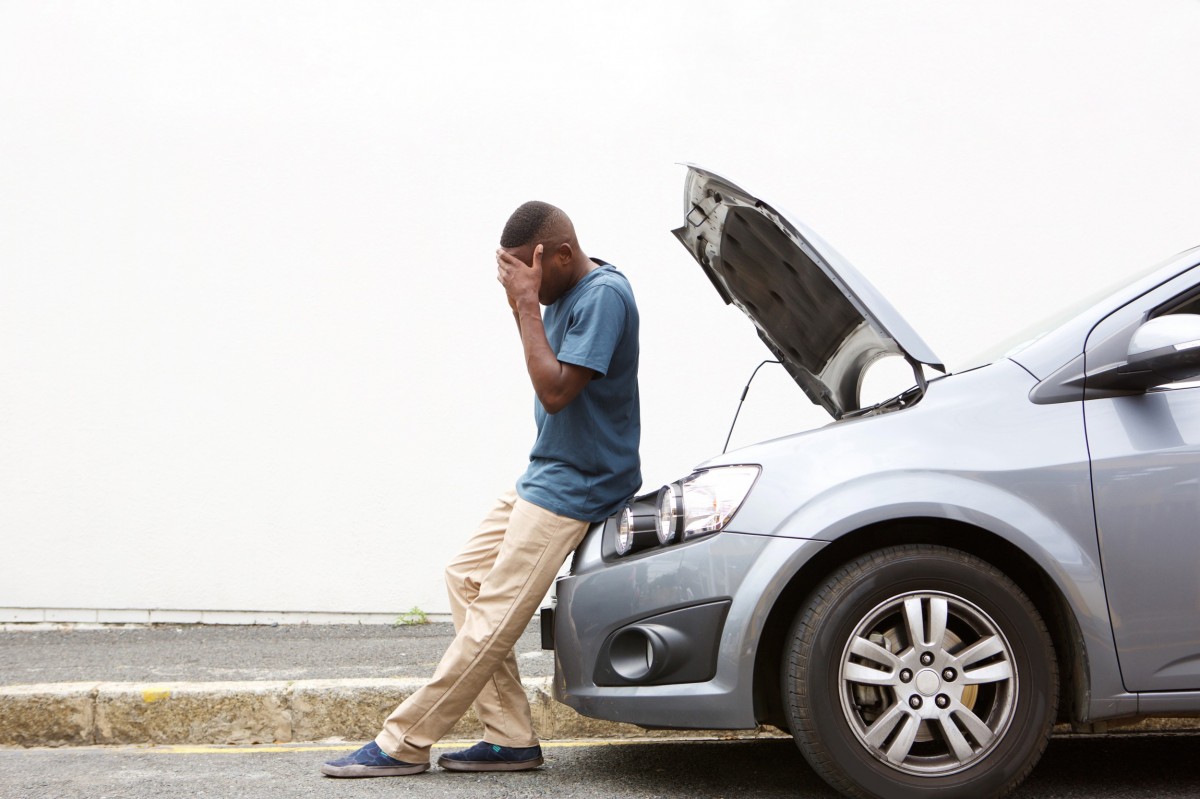 man broke down on side of road with hands on head