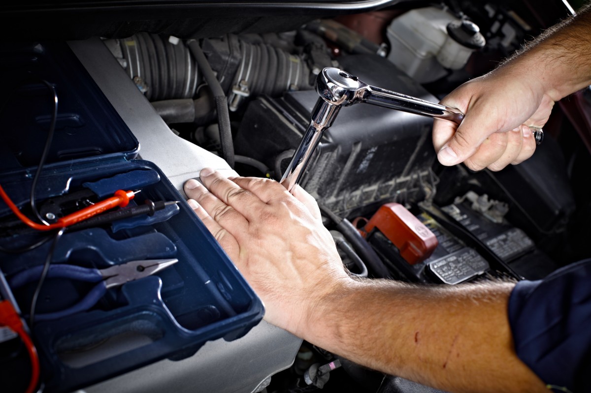 technician with a wrench working on the engine