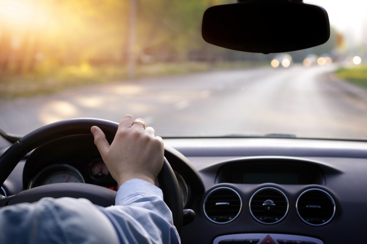 Person driving with hands on the steering wheel