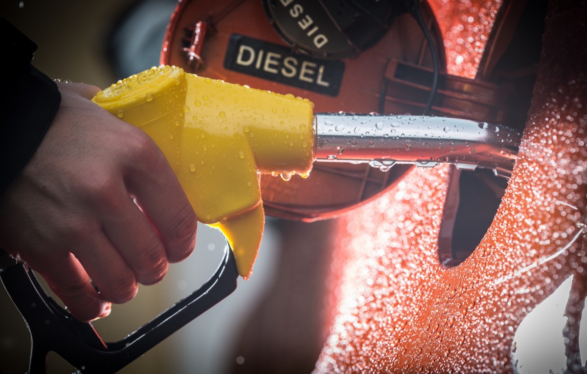 fuel nozzle that reads diesel being put into a fuel tank on vehicle